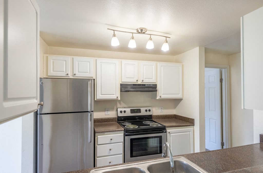 a kitchen with white cabinets and stainless steel appliances