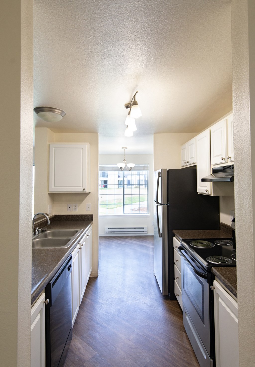 an open kitchen with white cabinets and black appliances