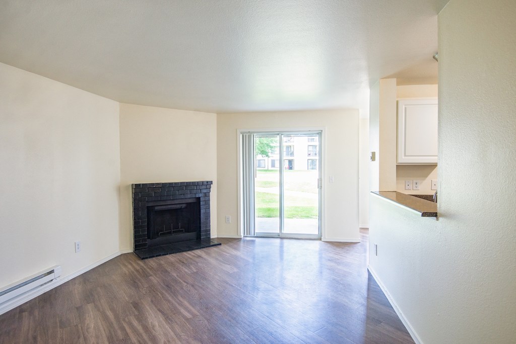 a living room with a fireplace and a doorway into a kitchen