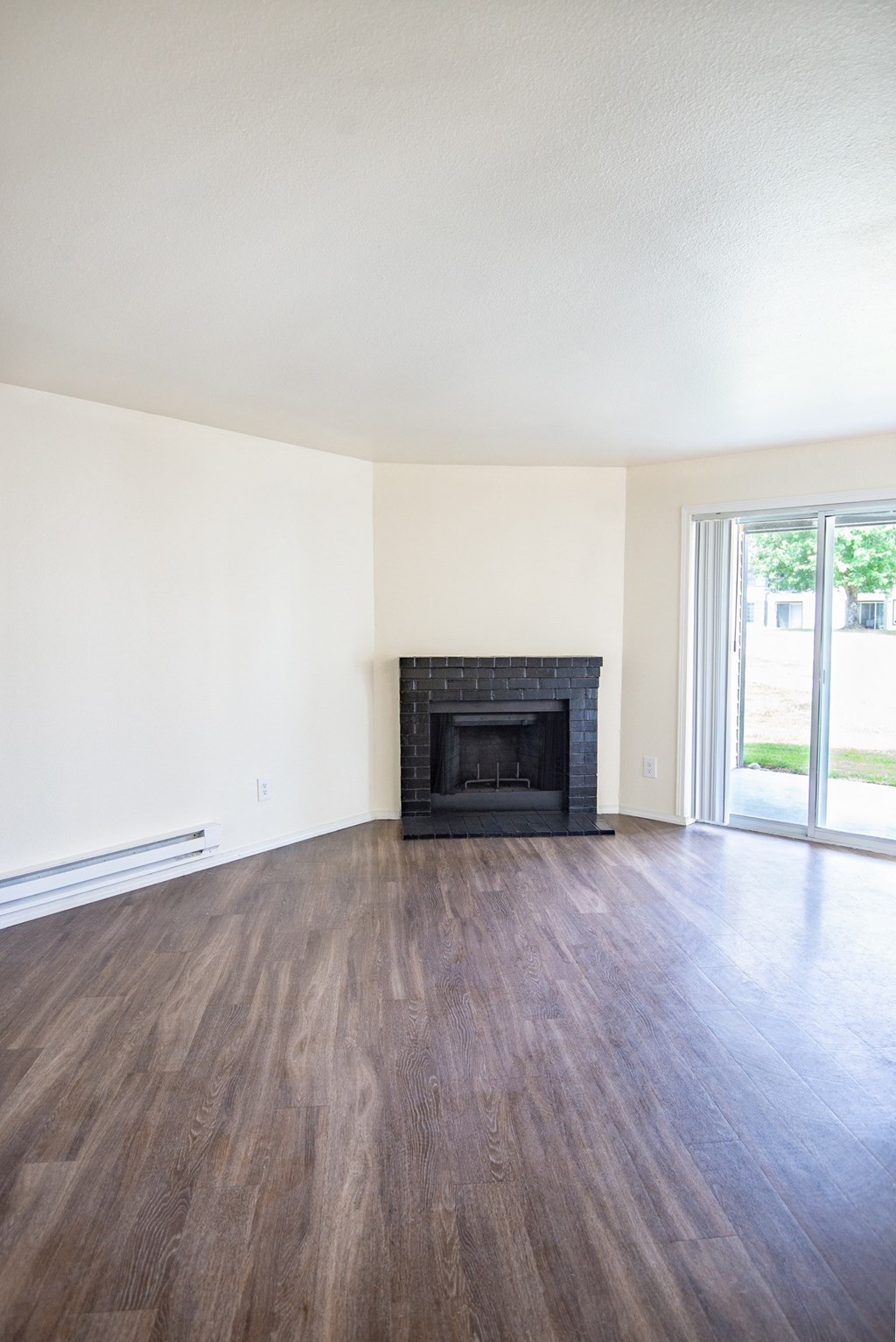 a living room with hardwood floors and a fireplace