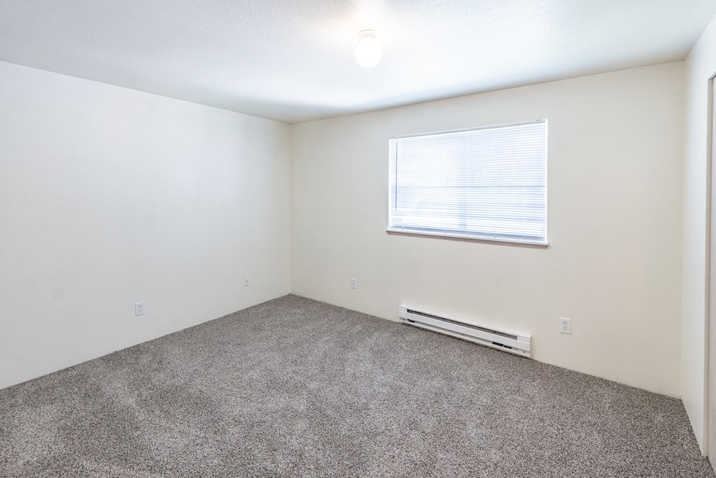 a bedroom with white walls and carpet
