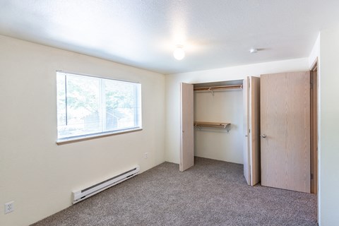 a small bedroom with a closet and a window