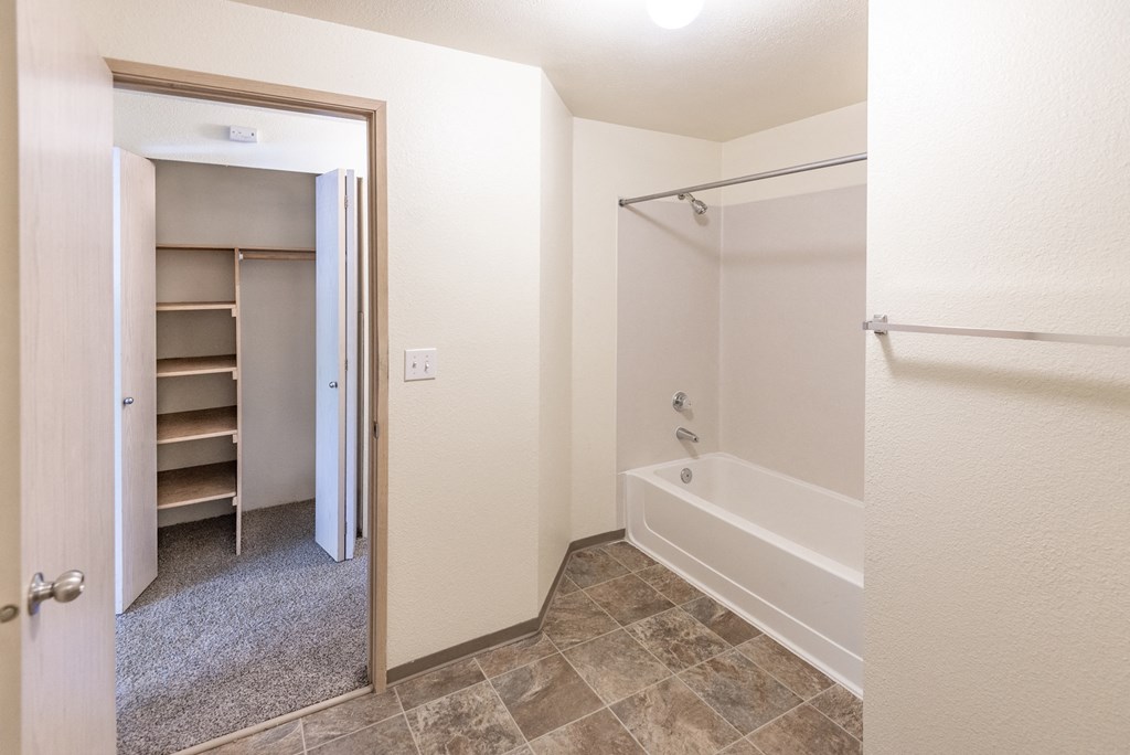 a bathroom with a bathtub and a closet