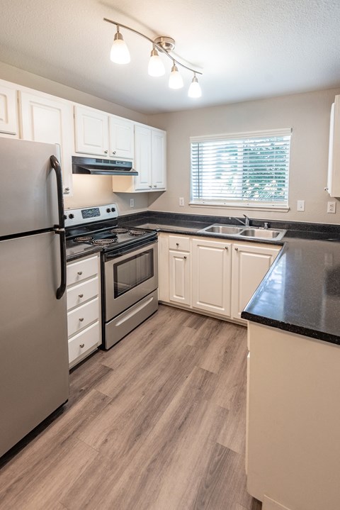 a kitchen with white cabinets and stainless steel appliances