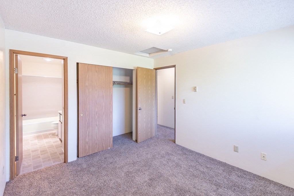 a bedroom with white walls and a carpeted floor