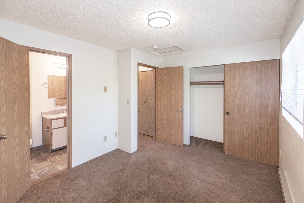 a bedroom with white walls and a carpeted floor