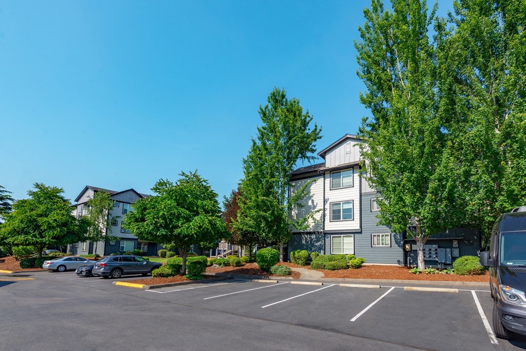 an empty parking lot in front of an apartment building