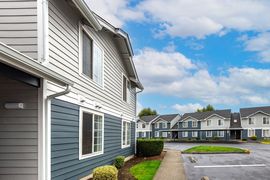 a row of houses with blue siding and a parking lot