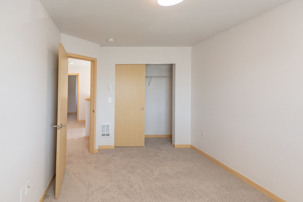 a bedroom with white walls and carpet