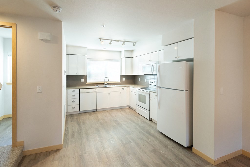 a kitchen with white appliances and white cabinets