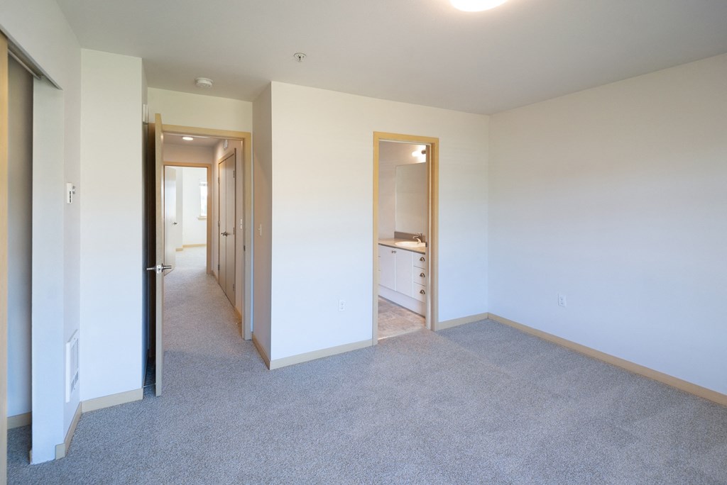 a bedroom with white walls and carpet
