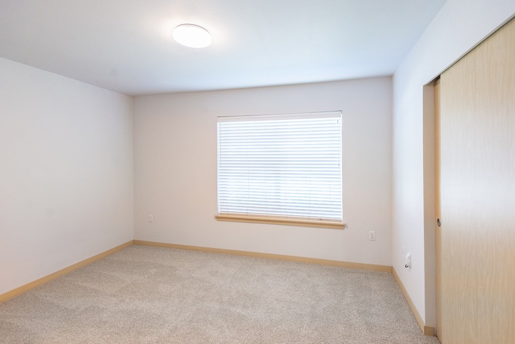 a bedroom with a large window and a wooden door