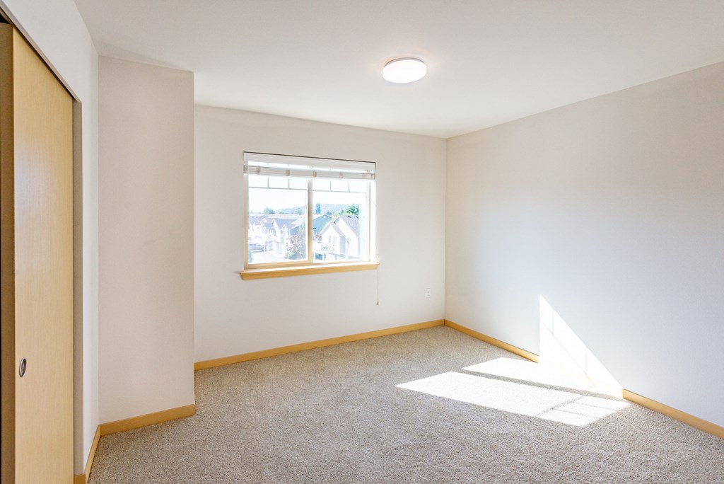 an empty room with a window and a door