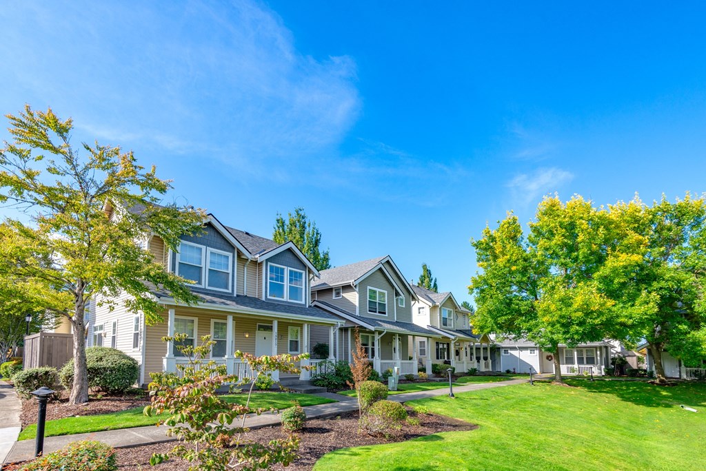 a row of houses with lawns and trees