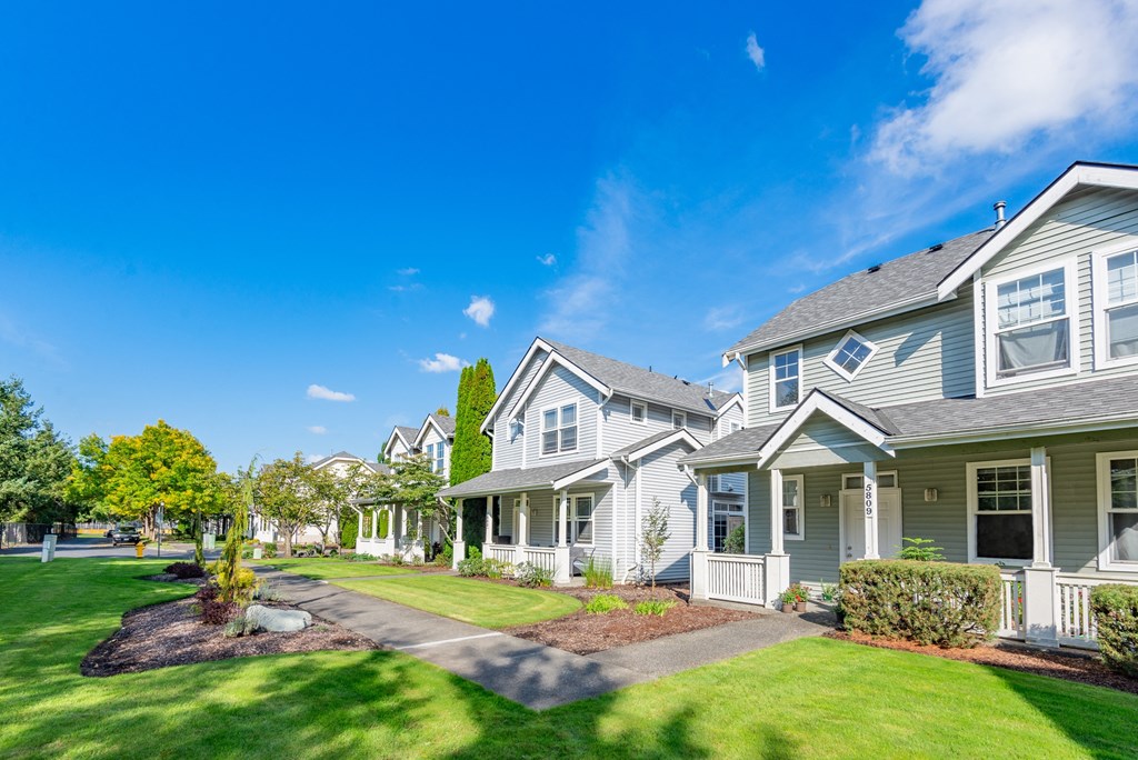 a row of houses with lawns and trees