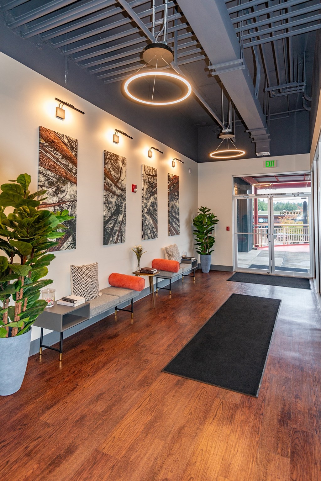 a lobby with chairs and plants and a glass door