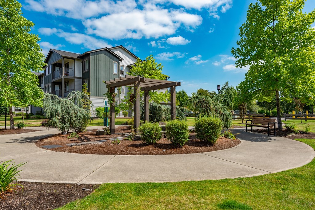 a park with a pavilion and benches in front of a building