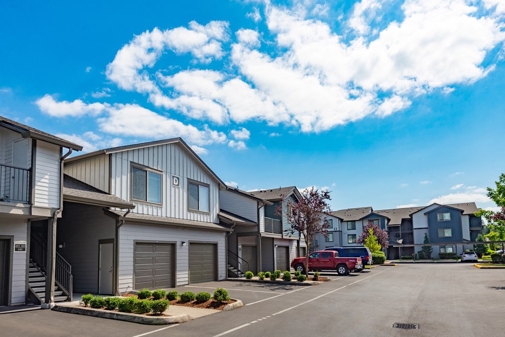 a row of houses with a red truck parked in a parking lot
