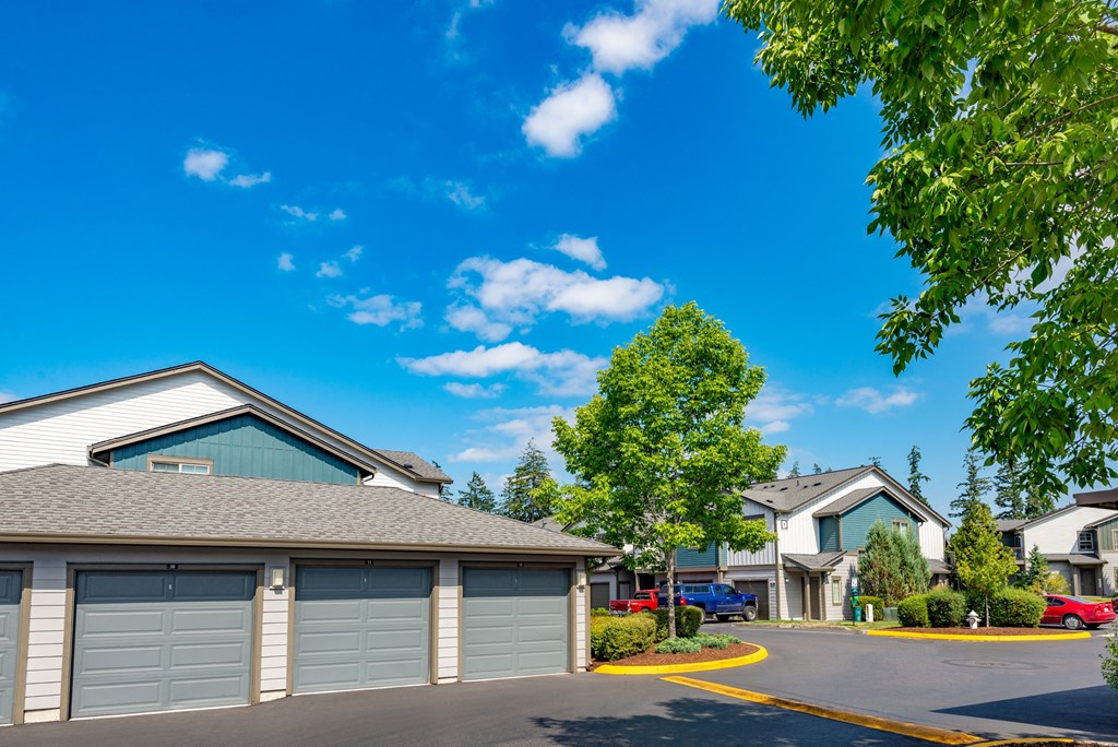 a neighborhood of garages with cars parked in front of them