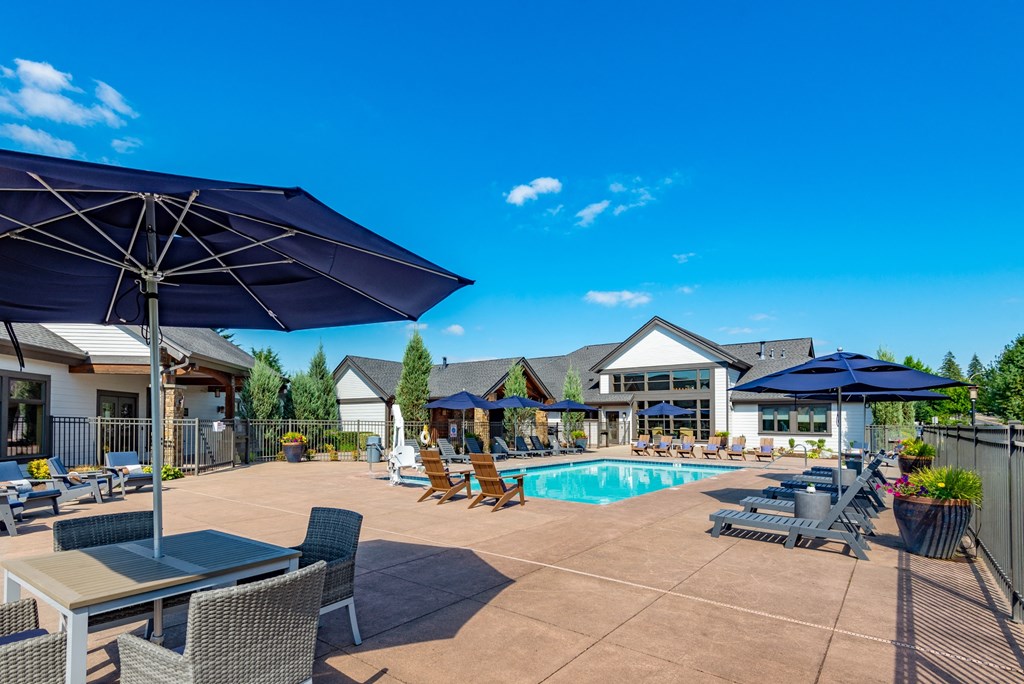 our apartments have a pool and patio with chairs and umbrellas