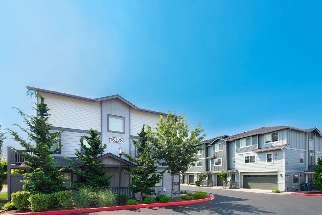 the view of an apartment building with a street in front of it