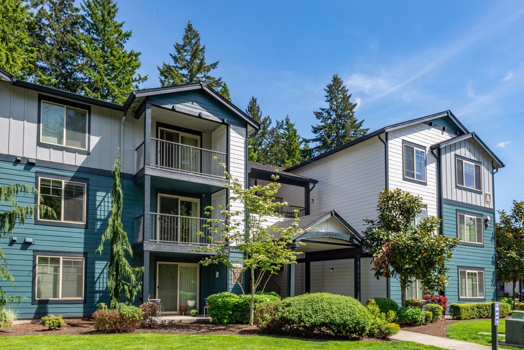 A row of townhouses with green trees in the background.