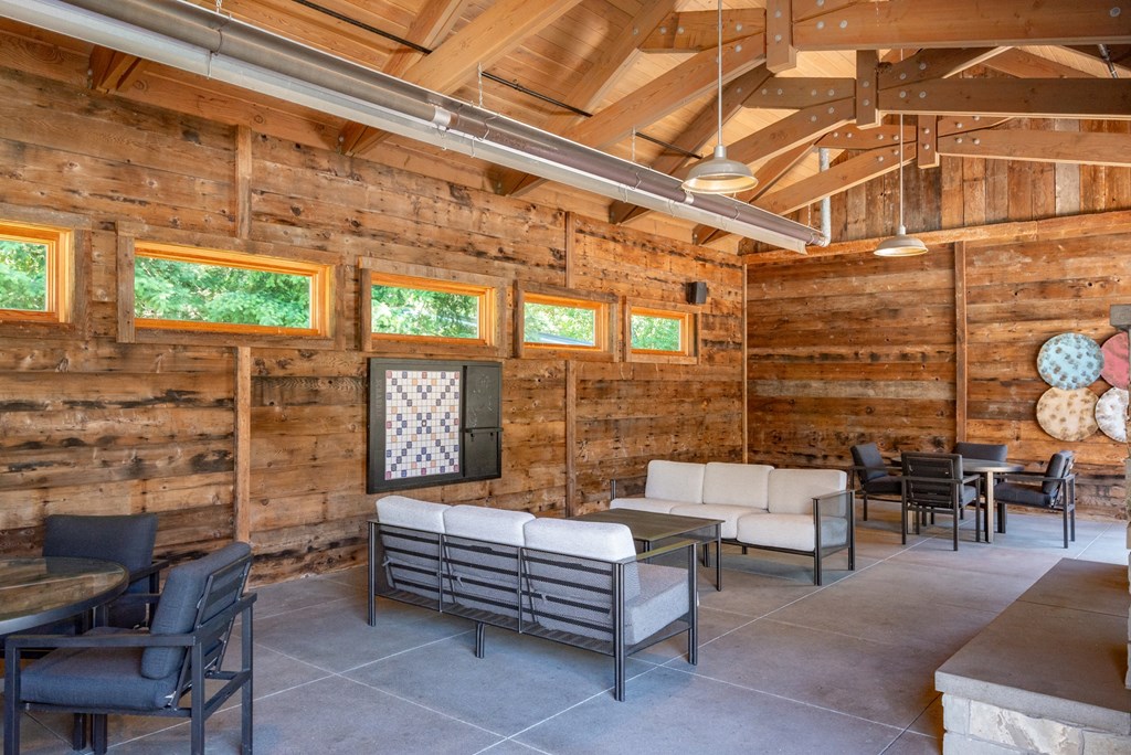 A wooden room with a couch, chairs, and a table.