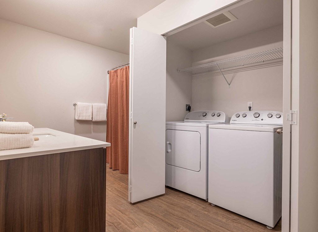 a laundry room with a washer and dryer and a closet with a white