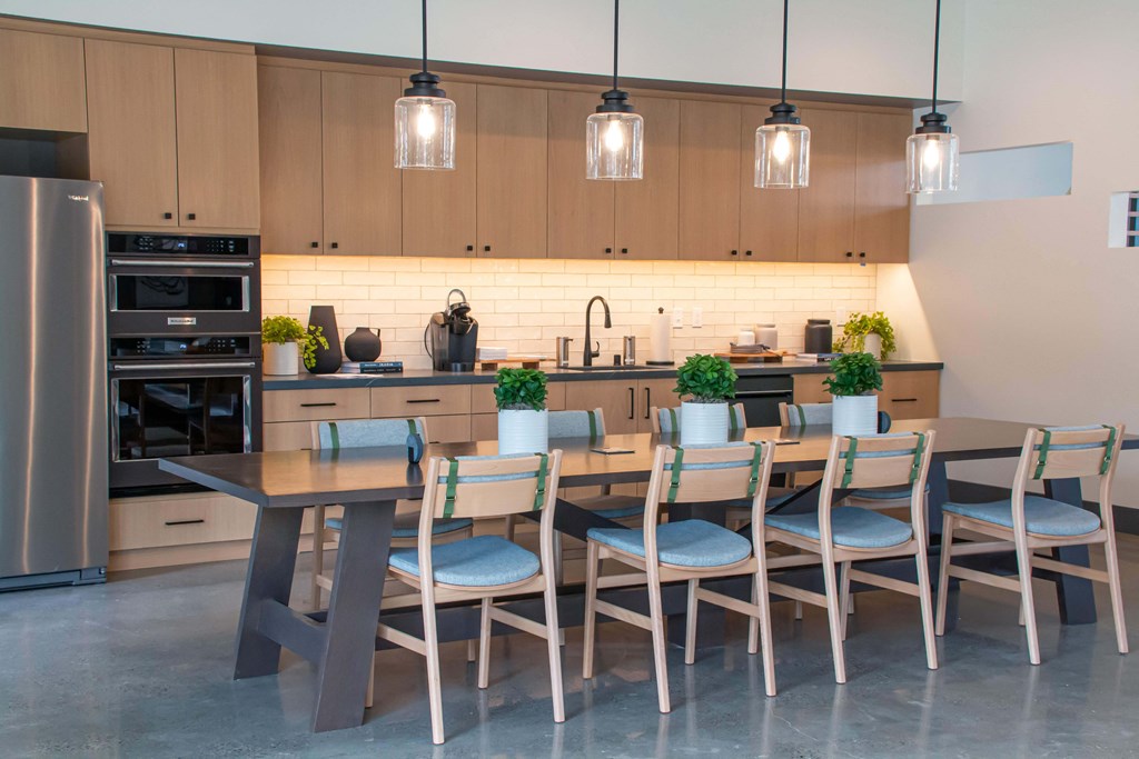 a large kitchen with a long wooden table and chairs