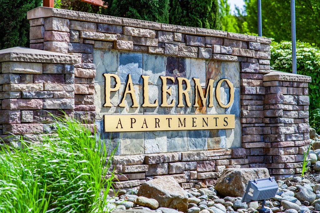 a sign for palermo apartments on a stone wall