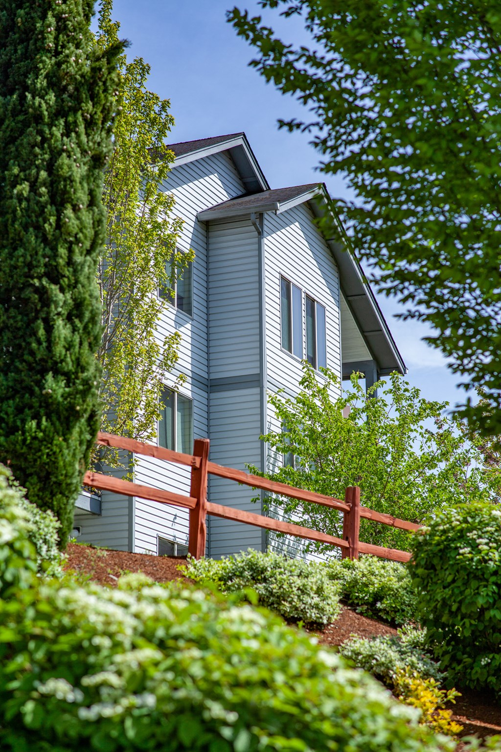 a house with a wooden fence in a garden