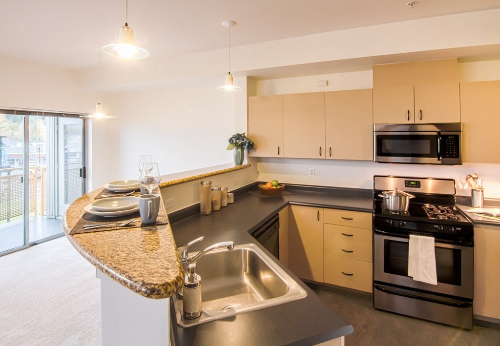 a large kitchen with stainless steel appliances and granite counter tops
