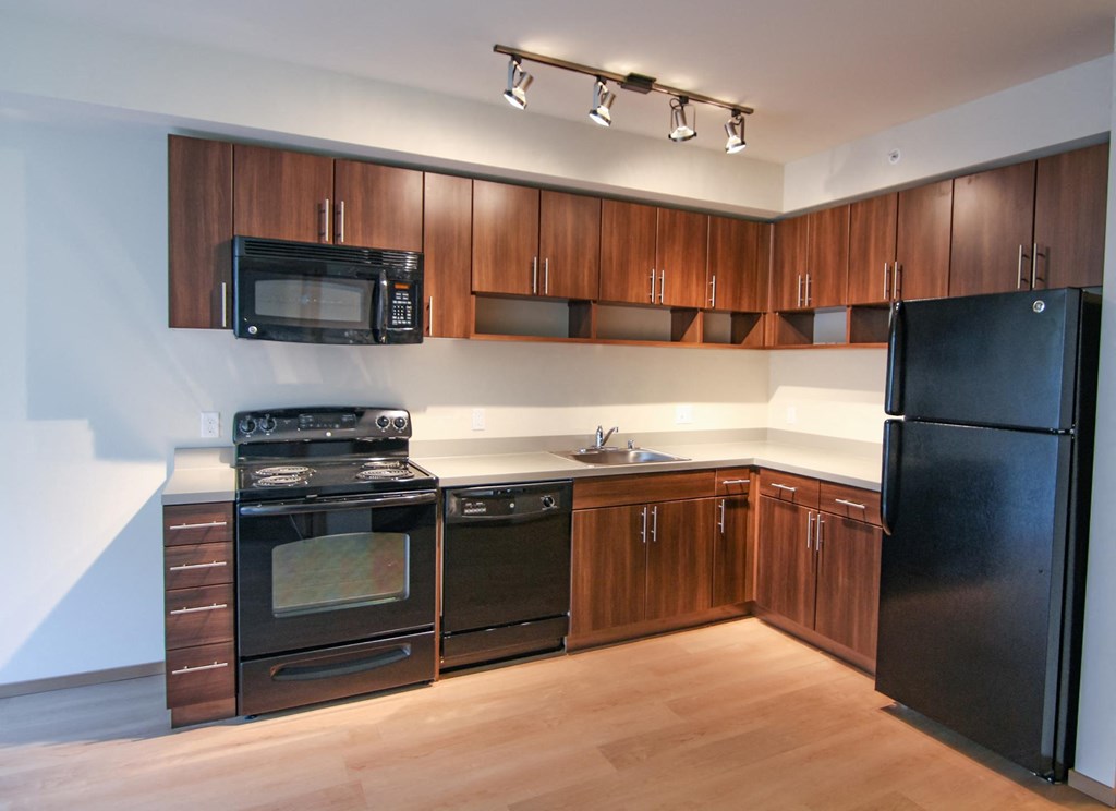 a kitchen with black appliances and wooden cabinets
