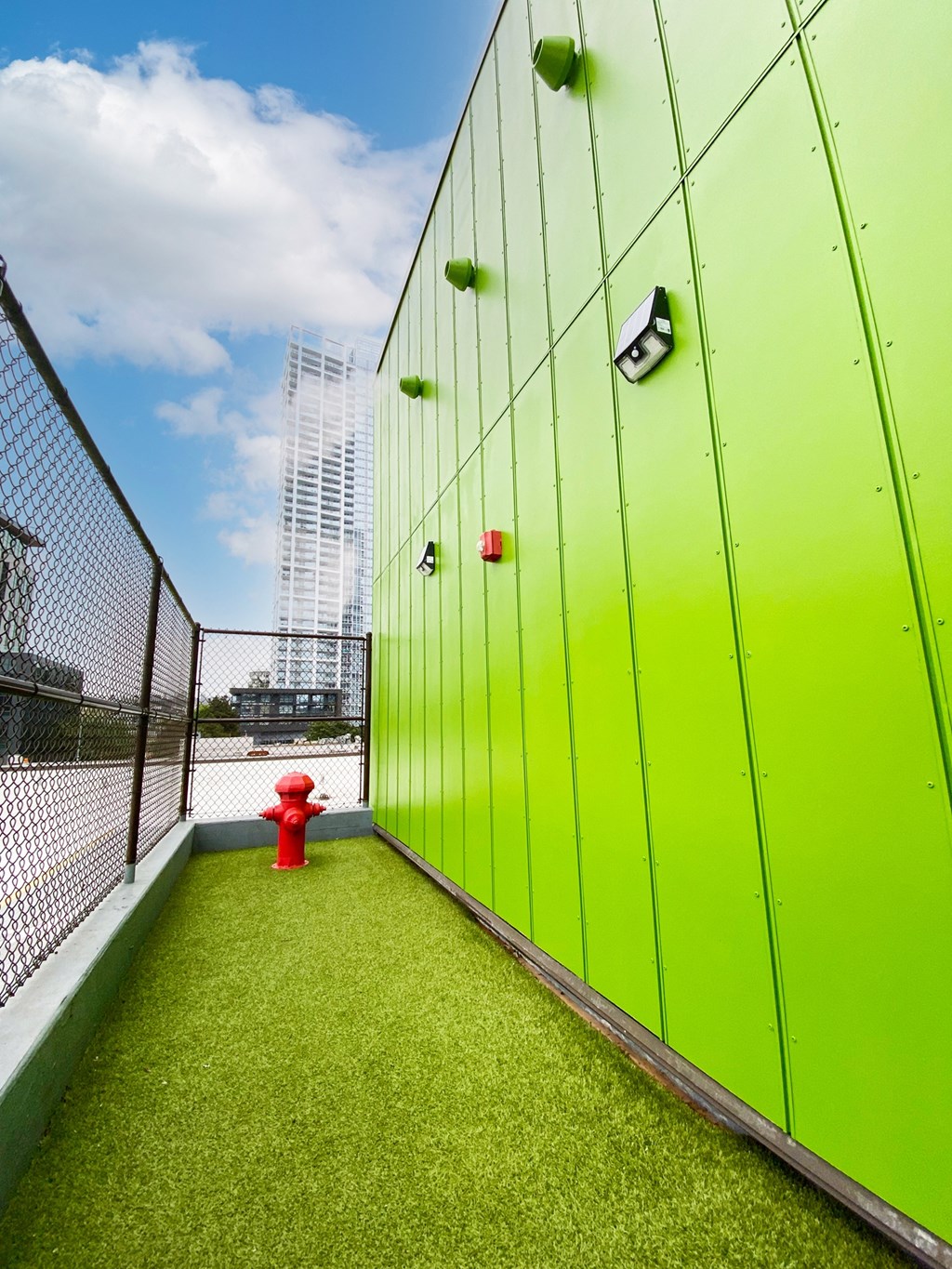 a fire hydrant on the side of a building with green doors