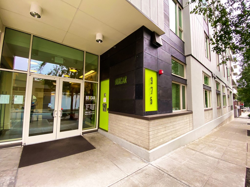 the front of a building with glass doors and a yellow sign