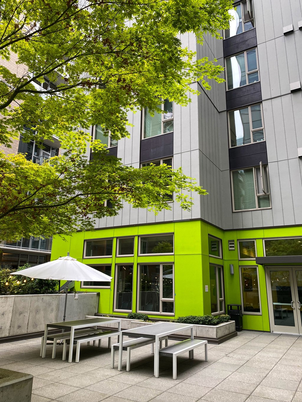 a courtyard with benches and tables in front of a building