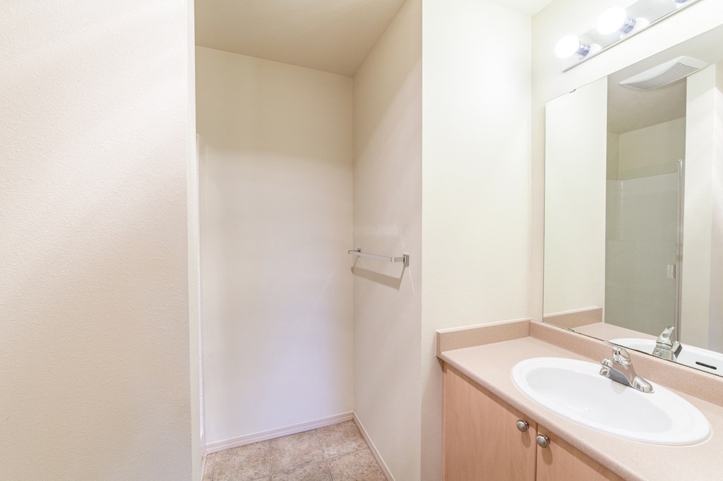 an empty bathroom with a sink and a mirror