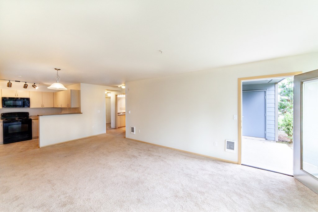 a large living room with a kitchen in the background