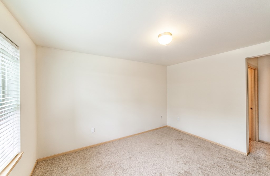 a bedroom with white walls and carpet