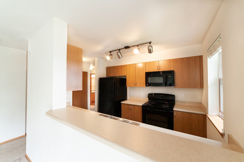 a kitchen with wood cabinets and black appliances