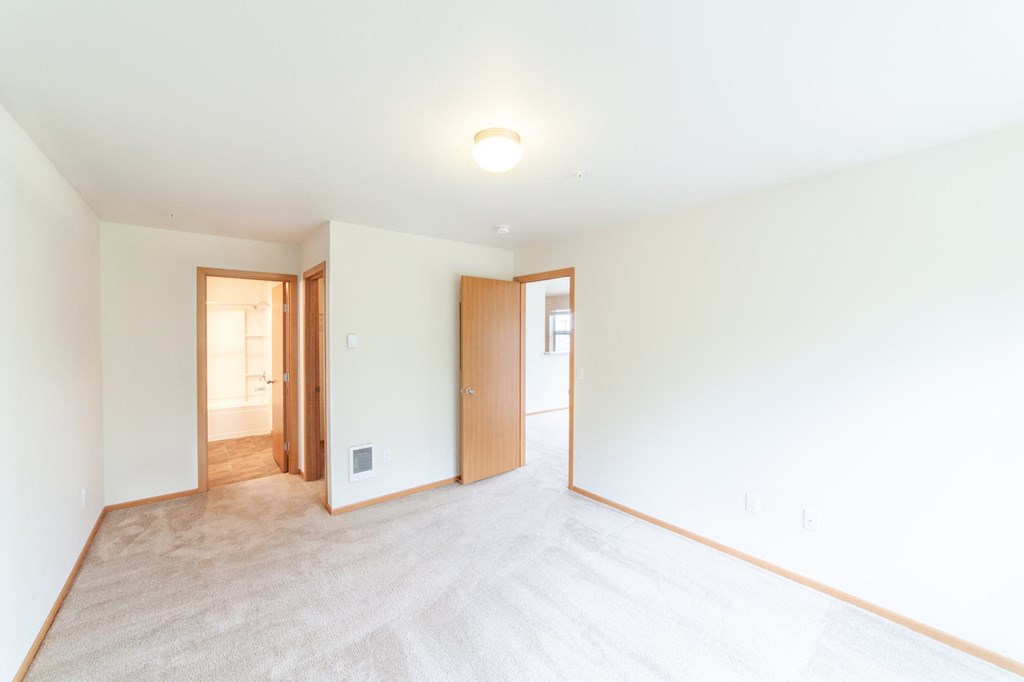 a bedroom with white walls and white carpet