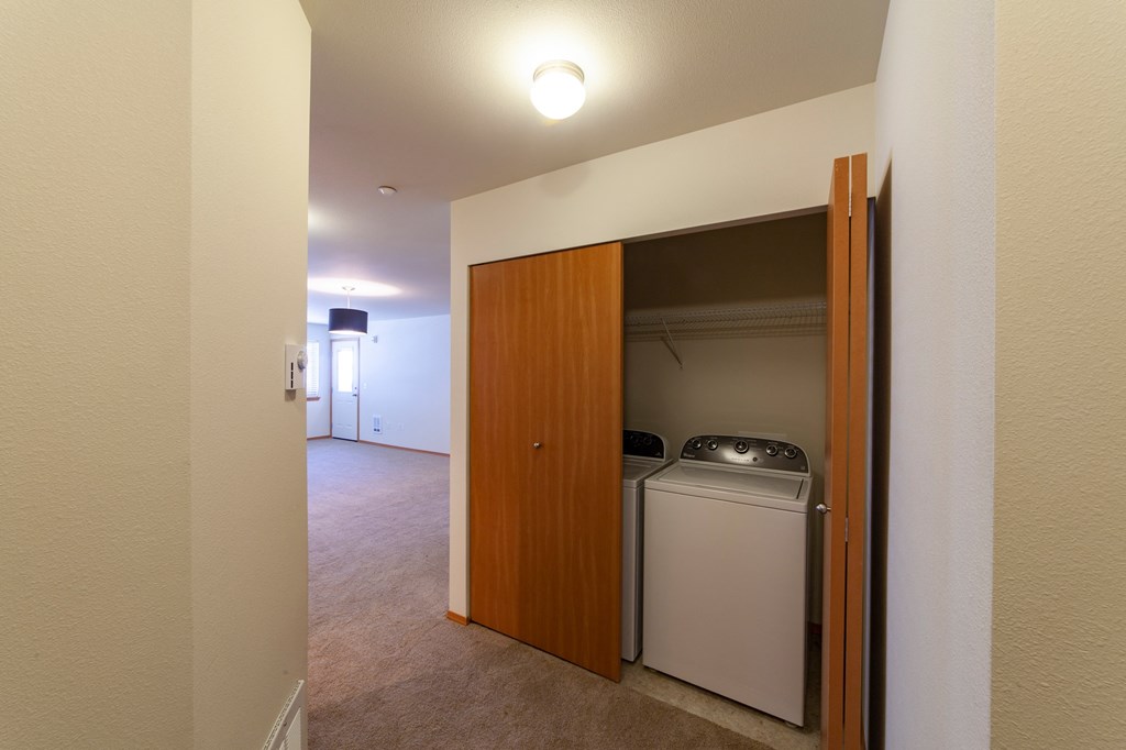 a laundry room with a washer and dryer and a door to a closet