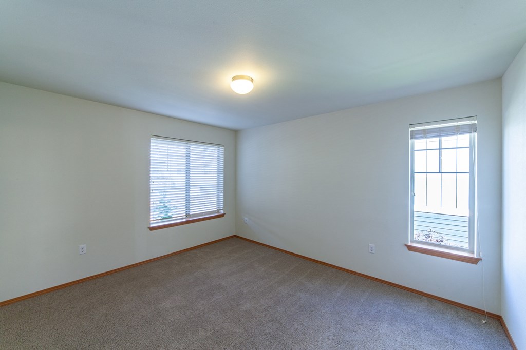 the living room of an empty house with two windows