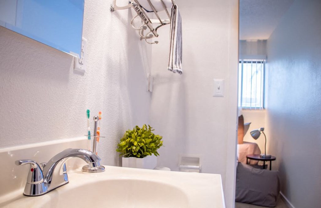 a white bathroom with a sink and a shower