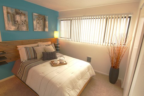 a bedroom with a bed and a vase with a plant