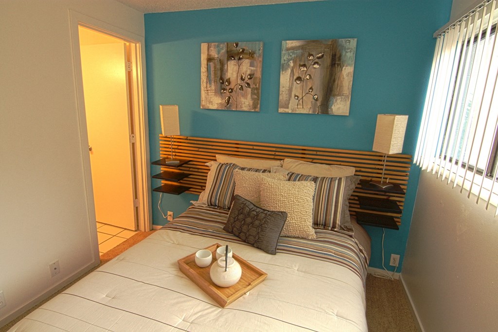 a bedroom with a bed and paintings on the wall