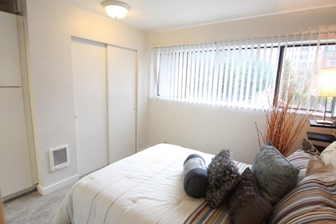 an empty bedroom with a bed and a window