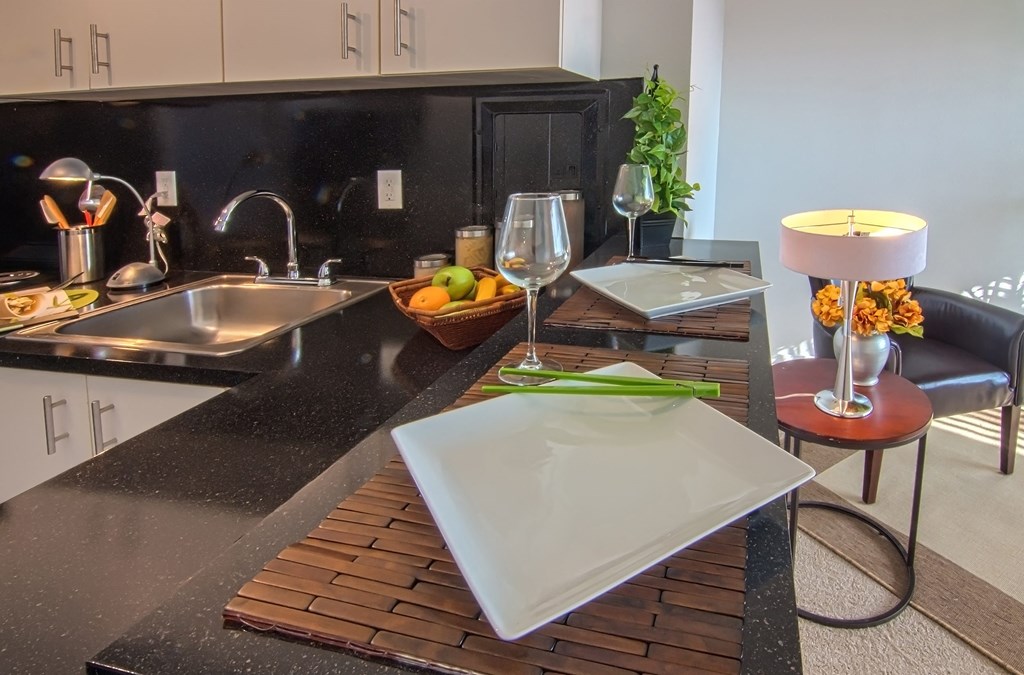 a kitchen with a sink and a table with a plate on it
