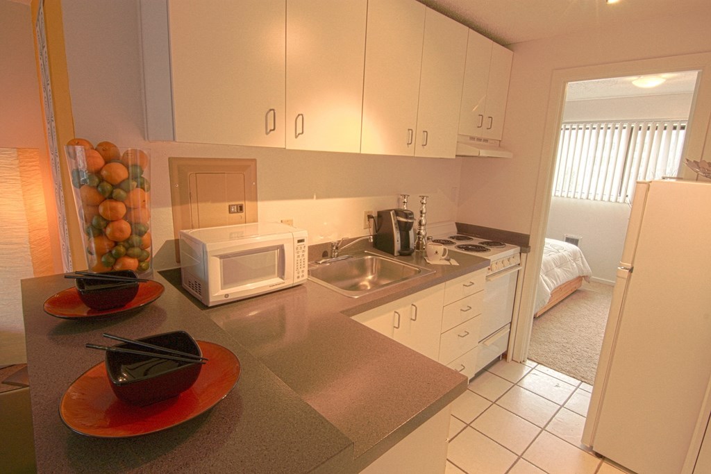 a kitchen with white cabinets and a sink and a microwave