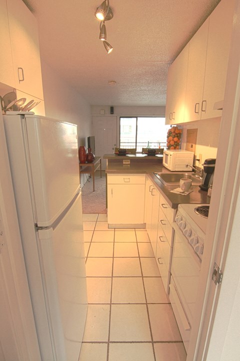 a view of a kitchen with white cabinets and a refrigerator